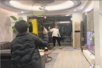  ?? Douyin user Wei Zikai / Associated Press ?? University student Wei Zikai has turned his living room into a badminton court in Wuhan, the Chinese city at the center of the virus outbreak that remains in lockdown.