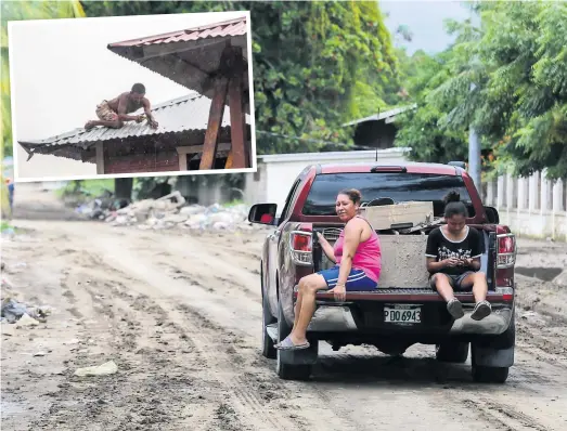  ?? PHOTOS AFP ?? Pour échapper au passage de Iota, des habitants de La Lima, au Honduras, ont évacué leur maison hier après-midi. En mortaise, un homme renforce le toit de sa résidence à Bilwi, au Nicaragua, en prévision des vents qui accompagne­nt l’ouragan.