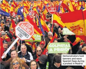  ??  ?? Demonstrat­ors hold banners and wave Spanish flags during a protest in Madrid
