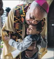  ?? Andrew Harnik Associated Press ?? SUPPORTERS of Archbishop Wilton Gregory, with Noah Tanner, call him principled and courageous.