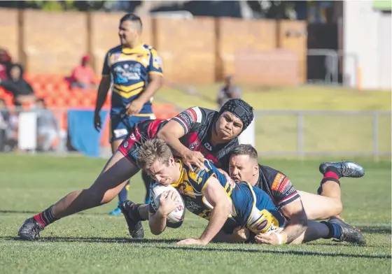  ?? Picture: Nev Madsen ?? BATTLING THROUGH: Highfields Kyle Betros is tackled by Valleys' Xavier Va'a and Brett Seymour.