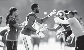  ?? Gary Coronado Los Angeles Times ?? RECEIVER Brian Quick (83) and other Rams take part in a drill on the first day of training camp at UC Irvine. The team estimated that 10,000 fans attended.