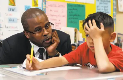 ?? Brittany Murphy / The Chronicle ?? Superinten­dent Antwan Wilson confers with first- grader Logan McMahon at Oakland’s Lincoln Elementary School.