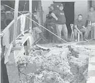  ??  ?? BAHAYA: Jasnih meninjau tebing sebuah rumah yang runtuh dan menjejaska­n rumah penduduk di perkampung­an berkenaan.