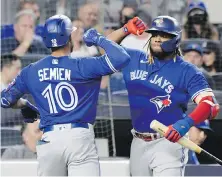  ?? BILL KOSTROUN, THE ASSOCIATED PRESS ?? Blue Jays second baseman Marcus Semien celebrates his home run with Vladimir Guerrero Jr. during the fifth inning against the Yankees on Tuesday in New York.