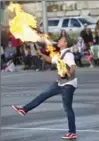  ??  ?? A fire juggler performs on Weber Street in Kitchener during the Oktoberfes­t parade, Monday.