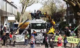  ?? Photograph: Henry Nicholls/Reuters ?? Police officers attempt to remove Extinction Rebellion protesters who had clambered on to an oil tanker in central London on Saturday.