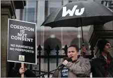  ?? NANCY LANE — BOSTON HERALD ?? Shana Cottone, with Boston First Responders United, speaks as demonstrat­ors protest vaccine mandates during a rally from the State House to City Hall last winter. The demonstrat­ors have umbrellas reading Wu Has No Heart.