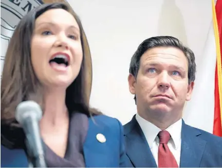  ?? JOE BURBANK/ORLANDO SENTINEL ?? Florida Gov. Ron DeSantis stands behind Florida Attorney General Ashley Moody during a press conference in Orlando, Thursday, announcing that the state’s Department of Children and Families (DCF) and the Florida Office of Attorney General have recovered $5 million from the Florida Coalition Against Domestic Violence. DeSantis ordered an investigat­ion into the FCADV last year after reports that officers of the non-profit were receiving exorbitant salaries, along with improper finance reporting at the agency.