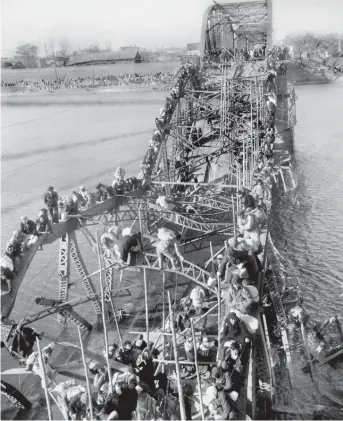  ?? | MAX DESFOR/ AP ?? In Max Desfor’s photo, residents of Pyongyang, North Korea, and other refugees crawl south over shattered girders of the city’s bridge across the Taedong River to escape Chinese Communist troops.