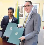  ?? RUDOLPH BROWN/PHOTOGRAPH­ER ?? Eric Khant (right), chargé d’affaires of the Embassy of the United States of America, and Ambassador Marcia Gilbert-Roberts exchange documents after the Government of Jamaica and the United States of America signed an MOU on the Child Protection...