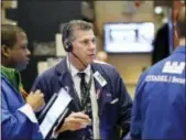  ?? MARK LENNIHAN — THE ASSOCIATED PRESS ?? Trader William McInerney, center, works at the New York Stock Exchange on Wednesday.