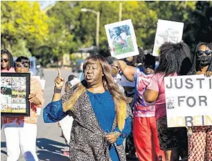  ?? PATRICK CONNOLLY/ORLANDO SENTINEL ?? Teresa Radford, a family friend of Adrein Green, calls out, “No justice, no peace,” during a vigil Tuesday where the 17-year-old was shot on Anderson Circle in Sanford.