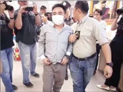  ?? ROBERTO SCHMIDT/AFP ?? Boonchai Bach (centre), a Vietnamese national with Thai citizenshi­p and alleged kingpin in Asia’s illegal wildlife trade, is escorted as he is processed at a police station in Bangkok on Saturday.