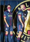  ?? JENNI GIRTMAN FOR THE AJC ?? Atlanta United’s Miles Robinson ( lef t) and Josef Martinez were among those unveiling the 2021 team uniforms — black top, shorts and socks with red stripes — last month at the Home Depot Backyard.