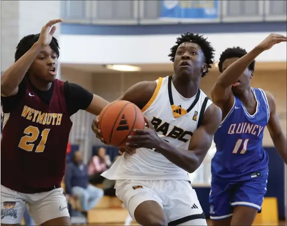  ?? PHOTO BY PAUL CONNORS — MEDIA NEWS GROUP/BOSTON HERALD ?? BABC U17star Joson Sanon, center, drives between Public/Catholic School Select defenders Eric Loussaint, left, and Danny Adams during the BABC Invitation­al tournament at Quincy High on Saturday.