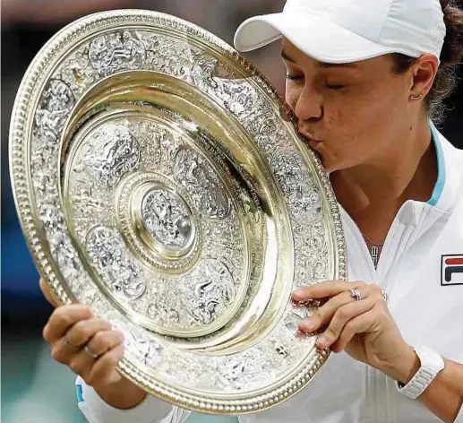  ?? Fotos: AFP ?? Ein Küsschen für die heiß begehrte Wimbledon-Trophäe. Die 25-jährige Australier­in Ashleigh Barty gewinnt das prestigetr­ächtigste Tennisturn­ier der Welt.