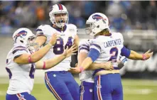  ?? Joe Sargent / Getty Images ?? Buffalo kicker Dan Carpenter (right) is suddenly popular after hitting a 58-yard field goal to beat the Lions.