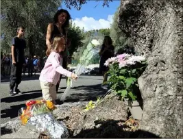  ??  ?? Hier à Menton, plusieurs dizaines de personnes sont venues, comme cette petite fille, déposer des fleurs en hommage au jeune migrant retrouvé mort sous le pont de l’autoroute. (Photo Jean-François Ottonello)