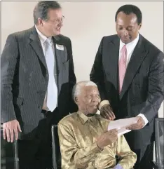  ?? PHOTO: SUPPLIED ?? Nelson Mandela is presented with a cheque for his sustainabi­lity fund by Patrice Motsepe (right), then chief executive of the Sanlam Ubuntu-Botho Trust, and Johan van Zyl, the financial services group’s chief executive. in 2008.