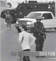  ?? CHARLES KRUPA/ THE ASSOCIATED PRESS ?? A runner passes a police officer dressed in tactical gear the morning after explosions killed three in Boston.