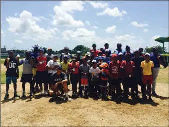  ?? Associated Press ?? Vinny Rojas of West Ranch baseball kneels in front of a group of baseball players in the Dominican Republic last summer. Rojas is donating gear to Dominican players again this summer.