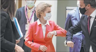  ?? Stephanie Lecocq The Associated Press ?? European Commission President Ursula von der Leyen, left, greets Luxembourg’s Prime Minister Xavier Bettel with an elbow bump Friday at an EU summit in Brussels, where leaders from 27 European Union nations gathered amid the pandemic.