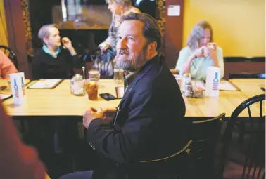  ?? CRAIG FRITZ/FOR THE NEW MEXICAN ?? Candidate for state land commission­er Garrett VeneKlasen speaks with potential voters last week at a meeting of the Cedar Crest Drinking Liberally social group at the Greenside Cafe.