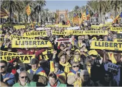  ??  ?? 0 Separatist­s hold banners outside parliament