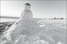  ?? BLEVINS/THE STAR-NEWS (WILMINGTON, N.C.] [KEN ?? This week’s “bomb cyclone” that traveled up the East Coast left enough snow for a snowman along the shore in Wrightsvil­le Beach, N.C.