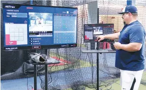  ?? The Sentinel-Record/Donald Cross ?? David Ashcraft, co-owner of 5-Tool Academy, demonstrat­es HitTrax technology on Thursday. The business has college and high school baseball and softball players who train their clients.