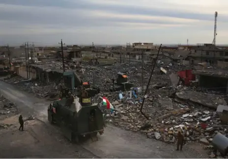  ?? JOHN MOORE PHOTOS/GETTY IMAGES ?? Peshmerga forces take positions on Sunday in Sinjar, Iraq. Kurdish forces, with the aid of airstrikes, liberated the town from Islamic State in recent days.