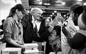  ?? SUSAN WALSH/AP ?? President Donald Trump and first lady Melania Trump serve food and meet evacuees Saturday in Houston’s NRG Center.