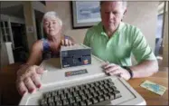  ?? ELAINE THOMPSON — THE ASSOCIATED PRESS ?? In this Wednesday photo, Kathy and Steve Dennis display their 1980’s-era Apple II+ computer bought for their then young sons in Bellevue, Wash. Three decades ago they never heard the phrase “screen time,” nor did they worry much about limiting the time the kids spent with technology, considerin­g the computer an investment in their future. Things have changed with their grandkids and their phones.