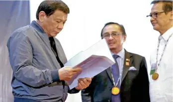  ?? SIMEON CELI JR./PRESIDENTI­AL PHOTO ?? PRESIDENT Rodrigo Roa Duterte reviews the documents presented to him during the 26th Mindanao Business Conference (Minbizcon) closing ceremony at the Xavier Sports and Country Club in Cagayan de Oro City on September 9, 2017.