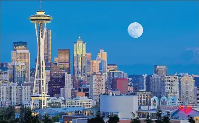  ??  ?? A full moon rises over the Seattle skyline dominated by the spectacula­r Space Needle