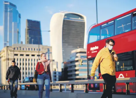  ??  ?? People cross London Bridge in the evening sunshine, London, Sept. 25, 2020.