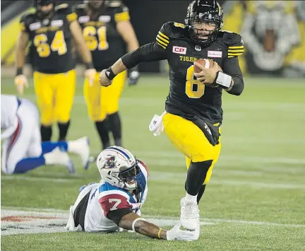  ?? PETER POWER/THE CANADIAN PRESS ?? Hamilton Tiger-Cats quarterbac­k Jeremiah Masoli scrambles to avoid Alouettes defensive end John Bowman during CFL action in Hamilton Friday night. Montreal’s 33-0 loss was the first time the team was held without a point since 1997.