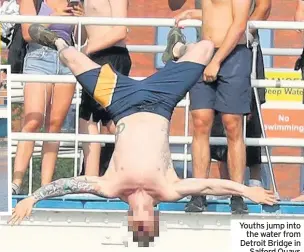  ??  ?? Youths jump into the water from Detroit Bridge in Salford Quays