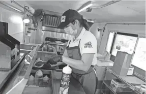  ?? MIKE DE SISTI / MILWAUKEE JOURNAL SENTINEL ?? Anytime Arepa co-owner Maria Salas prepares a beef arepa at Anytime Arepa food truck.