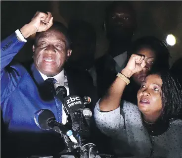  ?? TONY KARUMBA/AFP/GETTY IMAGES ?? Zimbabwe’s incoming president Emmerson Mnangagwa, left, gestures to supporters next to his wife Auxilia at ZanuPF party headquarte­rs Wednesday. Mnangagwa flew home Wednesday following the resignatio­n of Robert Mugabe.