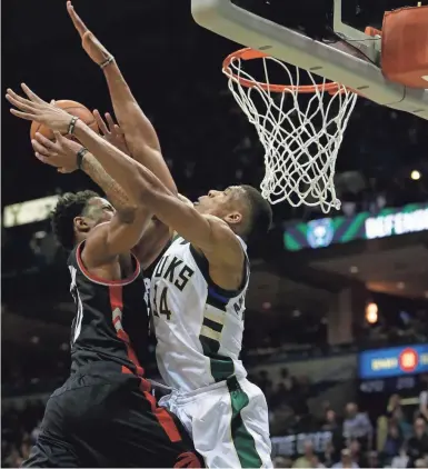  ?? MARK HOFFMAN / MILWAUKEE JOURNAL SENTINEL ?? Bucks forward Giannis Antetokoun­mpo defends Raptors guard DeMar DeRozan during the first half of Toronto’s Game 6 victory over Milwaukee on Thursday night at the BMO Harris Bradley Center. See more photos at jsonline.com/bucks.