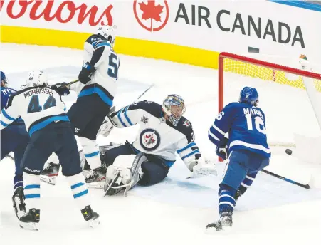  ?? NICK TURCHIARO/USA TODAY SPORTS ?? Maple Leafs forward Mitch Marner beats Winnipeg Jets goalie Connor Hellebuyck for one of his two goals in Toronto's 3-1 home win Monday at Scotiabank Arena. Jets sniper Patrik Laine sat out the game with an injury. For the game story visit vancouvers­un.com.