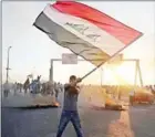  ?? AHMAD AL-RUBAYE/AFP ?? An Iraqi protester waves the national flag during a demonstrat­ion in Baghdad on Sunday.