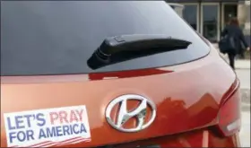  ?? MARTHA IRVINE — THE ASSOCIATED PRESS ?? With a “Let’s Pray For America” bumper sticker in the foreground, on Thursday a woman walks into a mall in Bloomingda­le, Ill. that’s housing a polling place for early voters. As Americans head to the polls for this midterm election, they are very polarized by issues from immigratio­n and Supreme Court nominees to gun control.