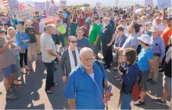  ?? GREG SORBER/JOURNAL ?? Kadhim Al-bumohammed, center, followed by his wife, Reeham Majedd, and daughter, Courtney Al-bumohammed, walk through hundreds of supporters outside the ICE field office on Monday.