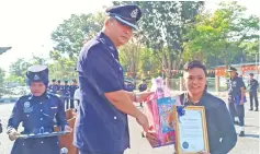  ??  ?? Sandra receives her certificat­e of appreciati­on and hamper from Lee, at the 212th Police Day celebratio­n.