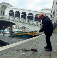  ?? La pulizia ?? L’acqua si è ritirata, un gondoliere pulisce la riva di Rialto.
In alto la libreria Bertoni in calle della Mandola deve eliminare i volumi bagnati (Foto Vision)