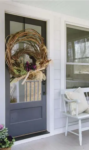  ??  ?? |ABOVE| FALL WELCOME. A friend made and donated the grapevine door wreath. Anne Marie embellishe­s itwith fresh purple mini calla lilies for a party.|OPPOSITE| MUDROOM MADE UP. Dirty old boots and a basket filled with new fall treasures share space inthe mudroom, with its handy built-in bench.