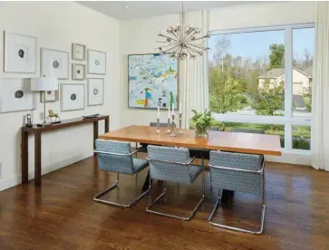  ??  ?? Above A walnut table and Knoll-inspired office chairs set the tone in the dining room. Tatiana framed slices of agate crystal on the wall to the left, bringing lustre to the room